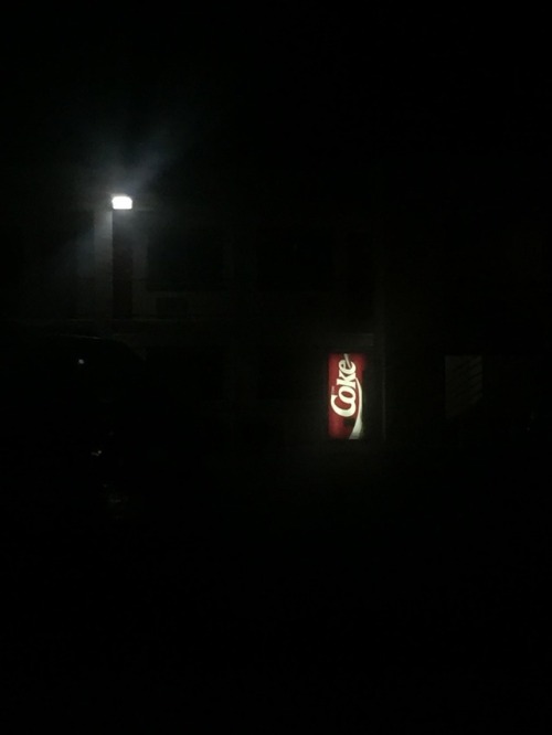 Dark Coke machine in phoenix parking lot
